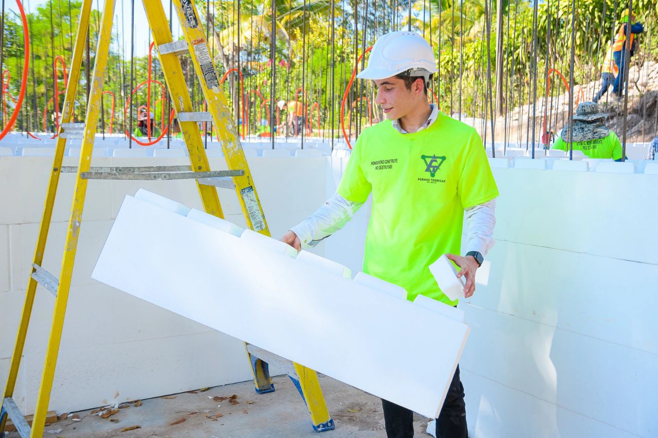 Estudiante de ingeniería manipulando bloques de EPS durante la práctica del sistema ICF en obra.